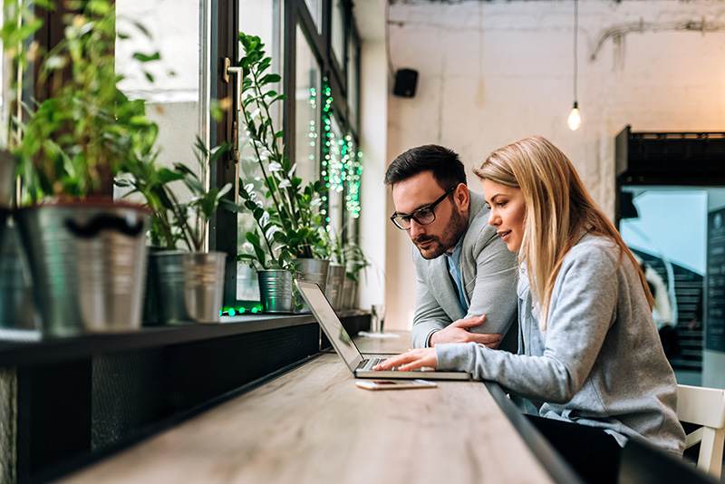 A woman and a men working on a laptop